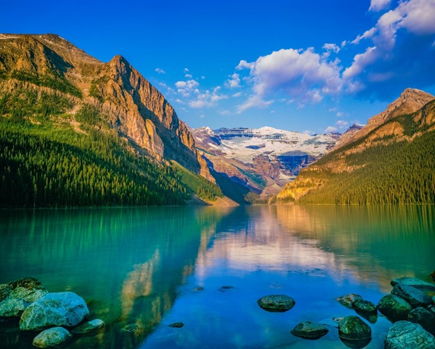 Early morning calm waters of Lake Louise reflecting the Canadian Rockies.