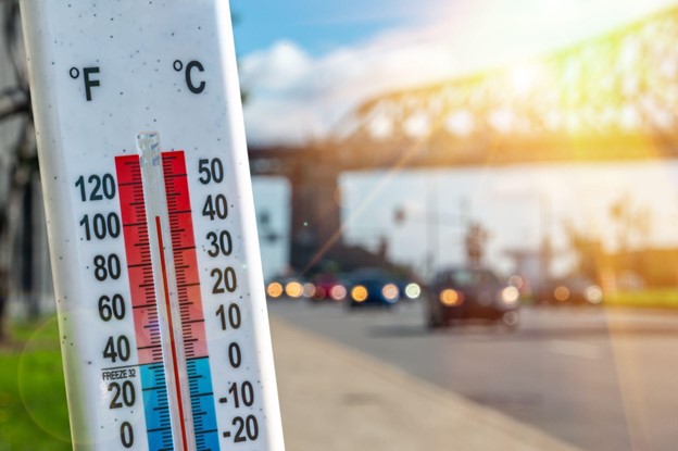 Thermometer in front of cars and traffic during heatwave in Montreal