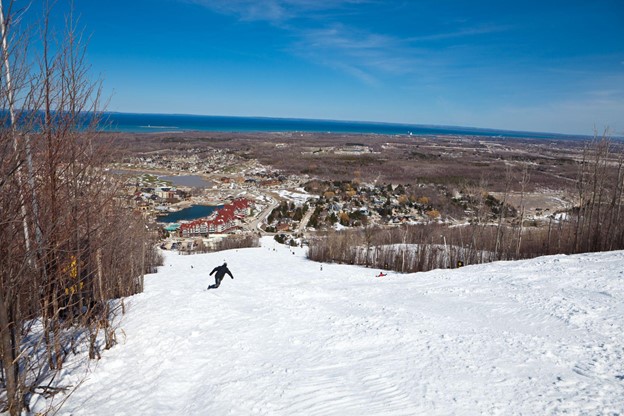 A man snowboarding down the Blue Mountain in Ontario, Canada
