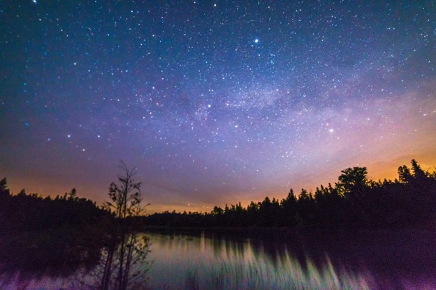 Small lake reflecting with stars and milky way at night near Lake Huron