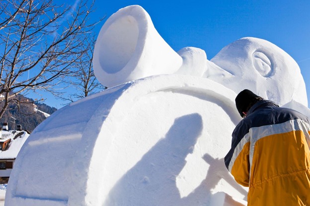 A man creating a snow sculpture 