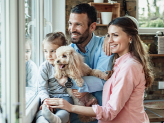 Family with their dog smiling in a pet-friendly short term rental home
