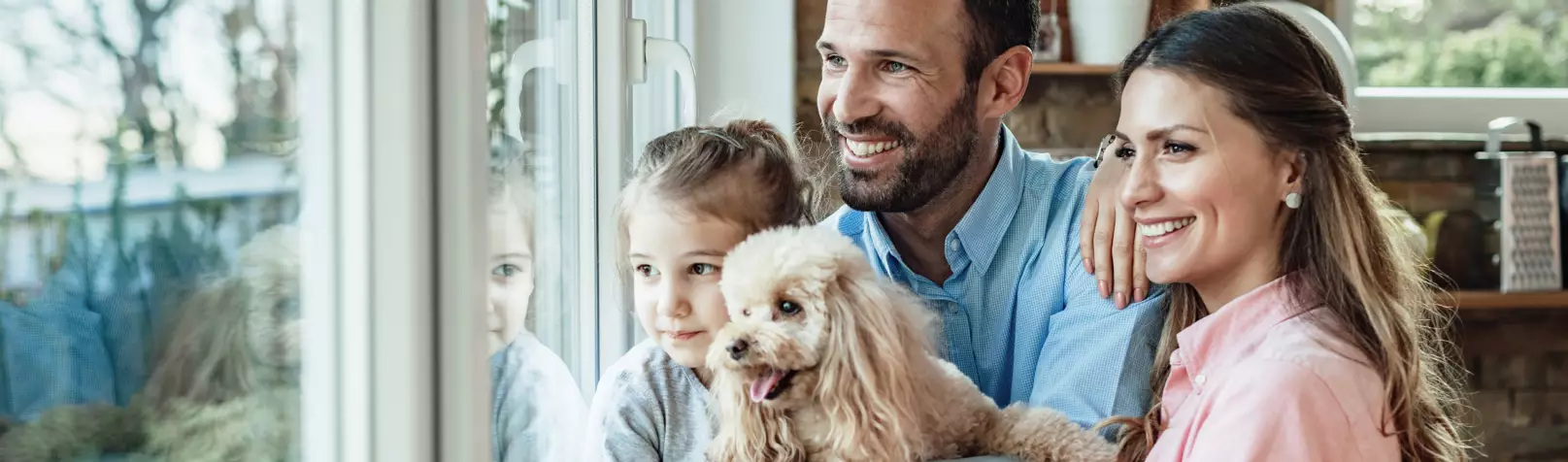 Family with their dog smiling in a pet-friendly short term rental home